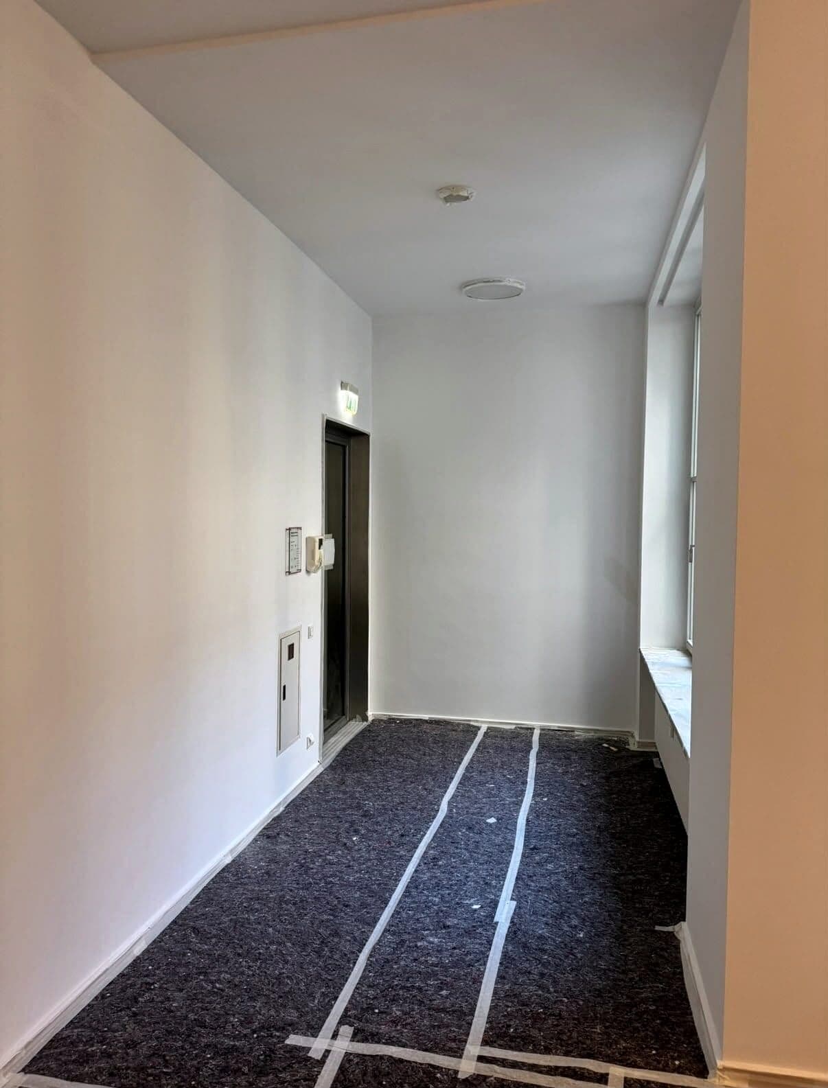 Flur während der Malerarbeiten, Boden mit Schutzvlies abgedeckt