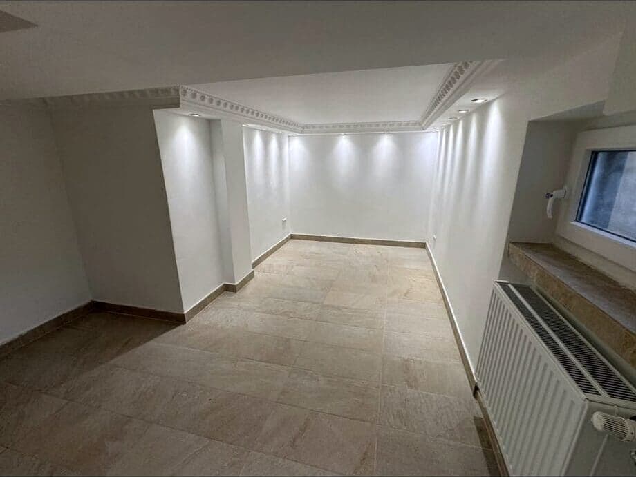 Ausgebauter Kellerraum mit Stuckleisten und neuem Fliesenboden