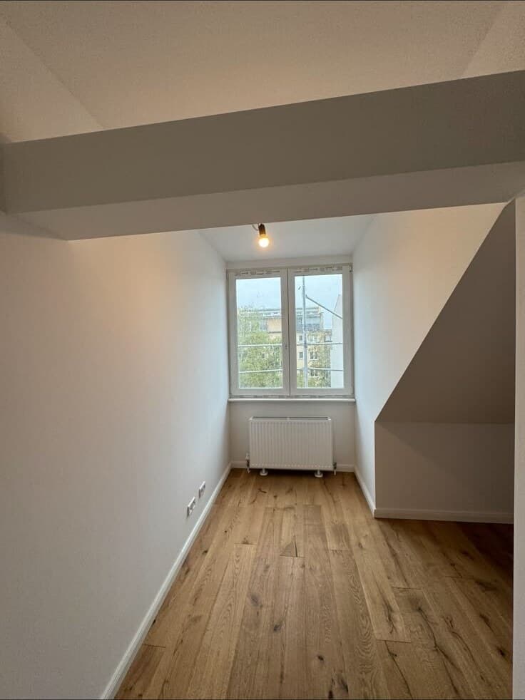 Fertig renovierter Altbauraum mit aufgearbeiteten Dielen